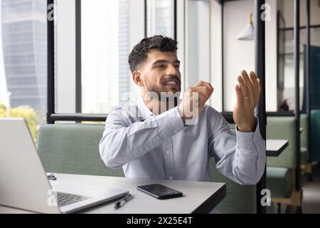 Positive young Arab businessman using invisible virtual interface Stock Photo