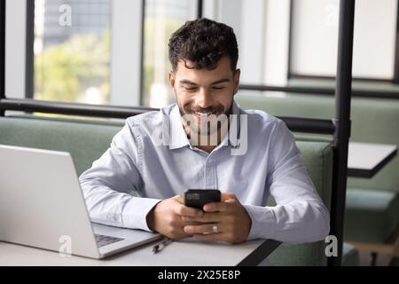 Happy successful young Arab freelance worker using digital gadgets Stock Photo