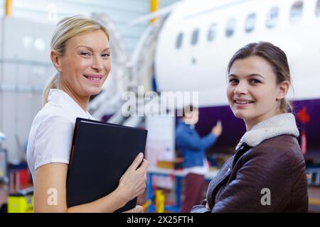 aero engineer and apprentice working in hangar Stock Photo