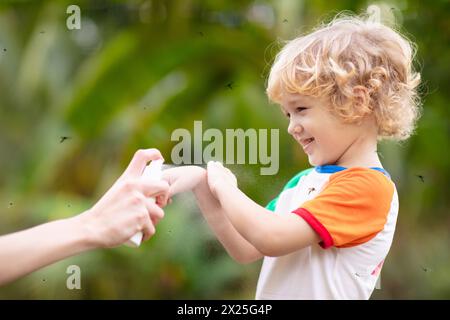 Mosquito on kids skin. Little boy attacked by mosquitoes in tropical forest. Insect repellent. Malaria and dengue fever prevention. Stock Photo