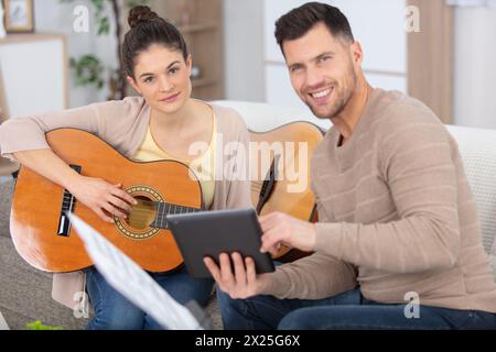handsome man teaches guitar to young woman Stock Photo