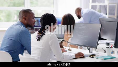 Working African business team of programmers coding on computer Stock Photo