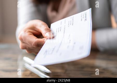Hand giving paycheck, check, cheque in transaction concept Stock Photo
