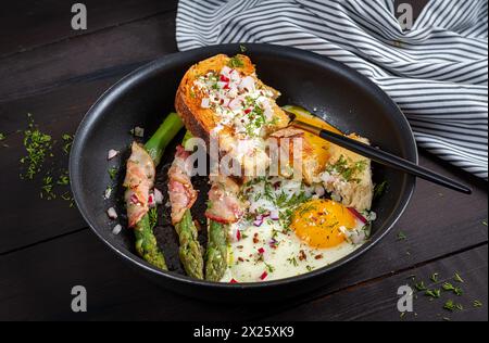 Keto breakfast. Fried eggs  with asparagus in bacon and toast. Stock Photo