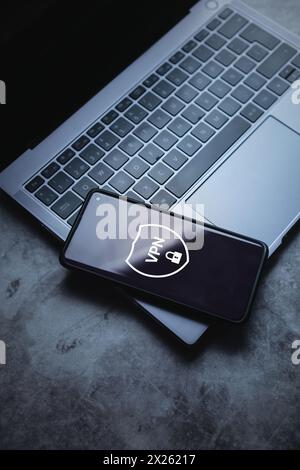 Smartphone laying on laptop with VPN app creation. Internet protocols for protection private network data. Stock Photo