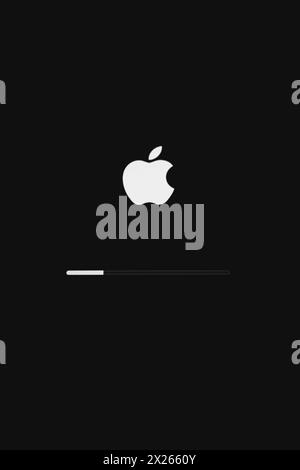 Kyiv, Ukraine - 04 14 2024: Apple icon on downloading screen. Download service. Macbook display. Modern gadget, vertical. Operating system. Stock Photo