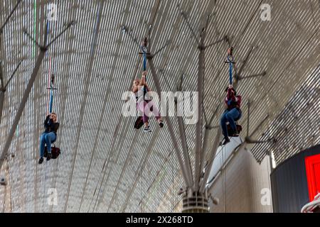 Las Vegas, Nevada.  Fremont Street.  Three Young Women Riding the SlotZilla Zipline. Stock Photo