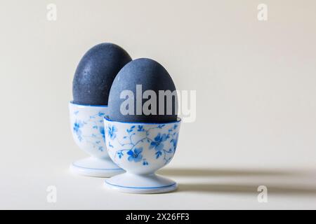 Eggs colored with wine in an egg cup on a light background. Easter concept. Stock Photo