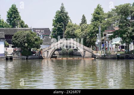 Excursion to Zhujiajiao water village, Shanghai, China, Asia, wooden boat on canal with view of historical architecture, old stone bridge over a calm Stock Photo