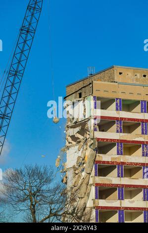 A multi-storey building is demolished under a clear blue sky Stock Photo