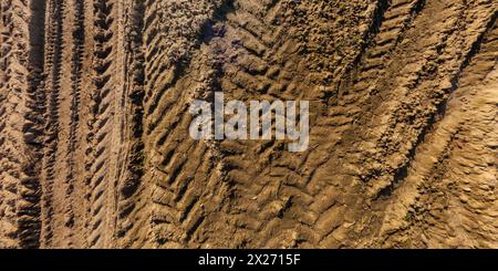 view from above on texture of wet muddy road with tractor tire tracks in countryside Stock Photo