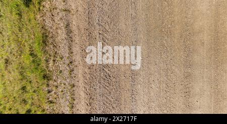 view from above on texture of wet muddy road with tractor tire tracks in countryside Stock Photo
