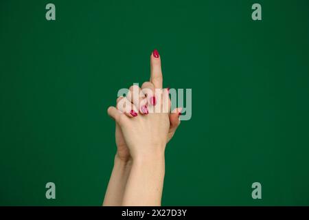 Woman's hand making shooting gun, gesture. hand pistol gesture on isolated white background. Woman hand pointing with fingers Stock Photo