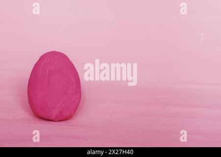 Decorative Easter dark pink egg on the background of fuchsia plaster. Greeting card Happy Easter. Stock Photo