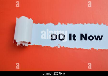 Concept of Do It Now Text written in torn paper. Stock Photo