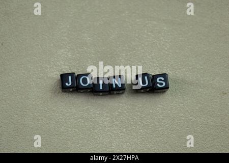 Concept of Join Us written on wooden blocks. Cross processed image on Wooden Background Stock Photo
