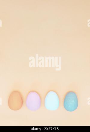 Brown, white, gray and lilac hand-painted decorative eggs on an uneven purple paper background. Spring holiday. Stock Photo