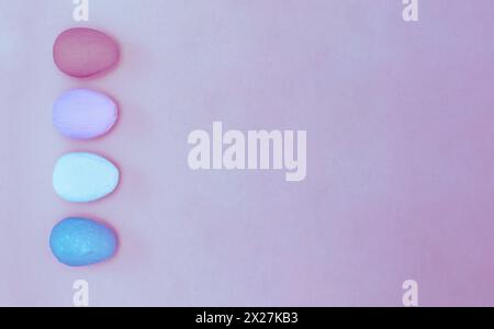 Pink, blue, white and purple homework eggs on uneven magenta paper background. Easter eggs on colored background. concept of a holiday and a happy Eas Stock Photo