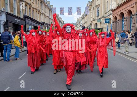 Bath, UK. 20th Apr, 2024. Dressed in their distinctive red rebel outfits the largest global assembly of the Red Rebel Brigade ever seen (400 in total) are pictured as they take part in a 'funeral for nature' procession through the streets of Bath to help raise awareness to the damage that mankind are doing to the planet. The event was planned to coincide with Earth Day and the Bath procession will be joined by nature campaigner Chris Packham who will deliver a ‘eulogy’ to the crowd at the finale of the event when it arrives in front of Bath Abbey. Credit: Lynchpics/Alamy Live News Stock Photo
