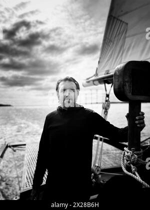 Half-length portrait of bearded mid-adult man standing on sailboat Stock Photo