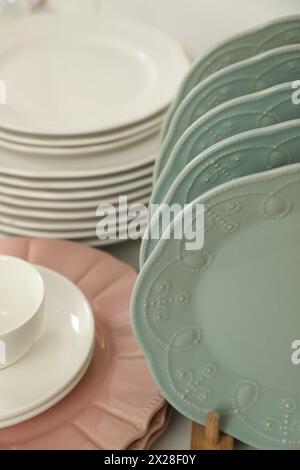 Many different clean plates on table in kitchen Stock Photo