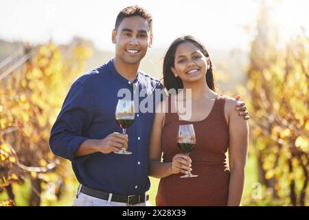Couple, portrait and happy at vineyard with glass for wine tasting, hug and vacation in countryside. Man, woman and smile with drink, alcohol and date Stock Photo
