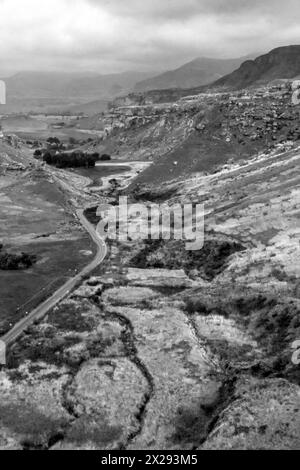 Black and White view of a highway in a valley in the Drakensberg Mountains of South Africa, on a clouded, rainy day Stock Photo