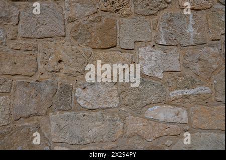 Old coarse panoramic stone wall made of various square natural stones in beige, ocher and brown 1 Stock Photo