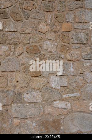 Light brown stone wall in panoramic close-up made of old, roughly hewn, different natural stones 1 Stock Photo