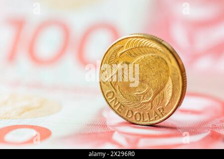 New Zealand dollar, Financial concept, 1 dollar coin with kiwi on the background of 100 dollar banknotes Stock Photo