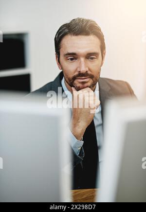 Business man, computer and thinking in office for information technology, software or online programming. Programmer or web developer reading on his Stock Photo