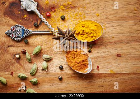 Spoons, spice and selection of seasoning for cooking on kitchen table, turmeric and cardamom for meal. Top view, condiments and options for spicy Stock Photo