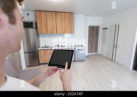 Worker with tablet computer checking alarm system indoors. Stock Photo