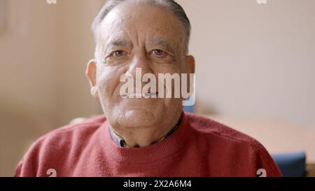 Old man smiling at camera sitting in nursing home Stock Photo