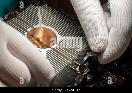 Aluminum cooling radiator with copper core mounted with a clamp by skilled service staff on the computer processor Stock Photo