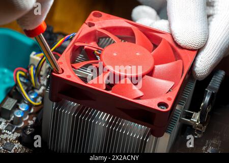 A technician installing fan-cooled heatsink onto the computer processor Stock Photo