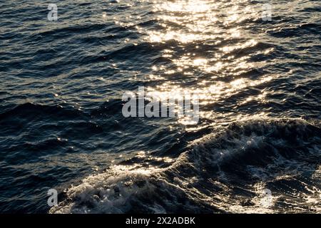 Lens star formed on water body on a sea, A calm ocean reflects sun stars in the morning light and foamy water Stock Photo