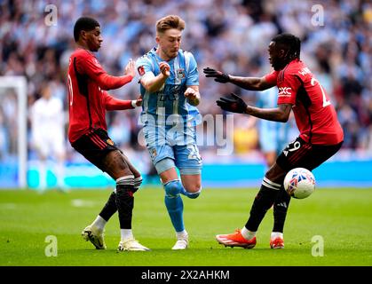 Coventry City's Josh Eccles (centre) battles for the ball with Manchester United's Marcus Rashford (left) and Aaron Wan-Bissaka during the Emirates FA Cup semi-final match at Wembley Stadium, London. Picture date: Sunday April 21, 2024. Stock Photo