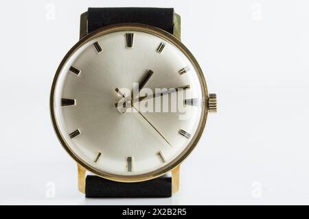 Timeless elegance, this handcrafted golden wristwatch from the 1960s exudes timeless sophistication, perfectly set against a white background. Stock Photo