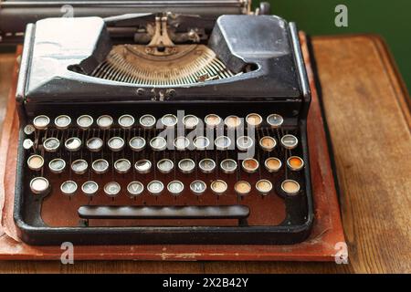 Ancient typewriter, old rusty typewriter on the wooden table. Stock Photo