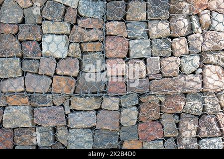 Gabion and rock armour - coast and waterways protection. Gabion walls constructed using steel wire mesh basket. Stock Photo