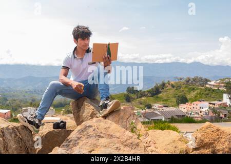 Lifestyle. A young Latino man reading his notepad outdoors. Stock Photo