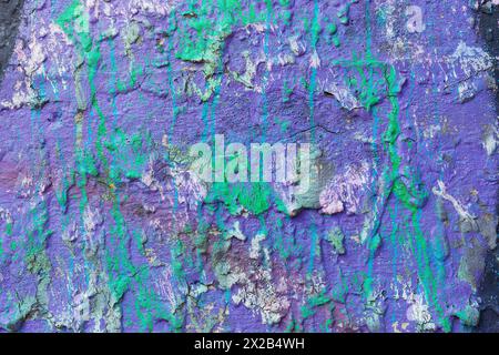 Violet color painted cement plastered wall with splashed green paint. Stock Photo