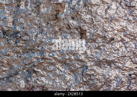 Rose silver colored old concrete wall with very uneven texture. Stock Photo