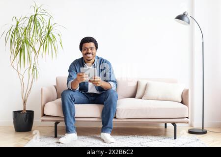 Man smiling while using digital tablet at home Stock Photo