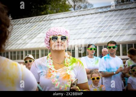 Walton Hall and Gardens, Warrington, Cheshire, UK. 21 April 2024 - Walton Hall and Gardens, Warrington, Cheshire, England - A Colour Run, Fun Run, took place in aid of St Rocco's Hospice. A woman protects her hair with a pink shower cap. St Rocco's Hospice is a place with care and respect at its heart. It supports patients physically, psychologically and emotionally to enable them to carry on living the lives they want to live for as long as possible and aims to help them improve the quality of life for them and for their loved ones. Credit: John Hopkins/Alamy Live News Stock Photo