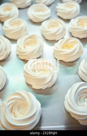 Close-up view many white meringue nests lying on tray Stock Photo