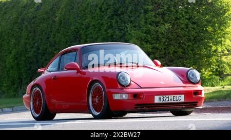 Bicester,UK- Apr 21st2024: 1990 red Porsche 911 Carrera 2 Coupe classic car driving on a British road Stock Photo