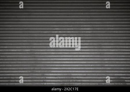 Front view of an old and weathered closed security roller door (or roller shutter, sectional overhead door, roll up or rolling garage door). Stock Photo