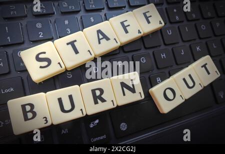 Staff burn out, in Scrabble letters & words on a computer keyboard Stock Photo